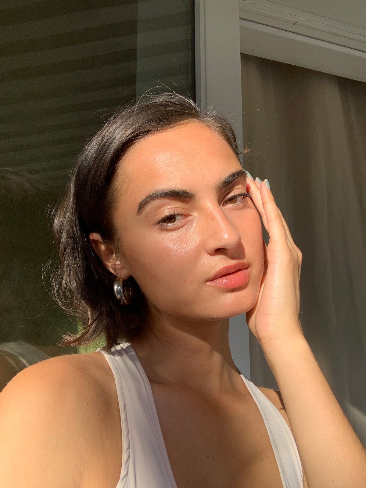 Model Moe Stuck in warm window light with a hand at her cheek