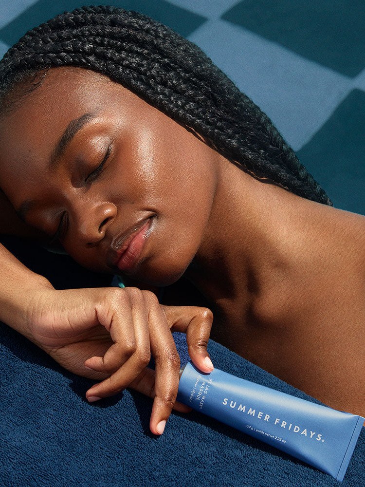 Model rests in blue light with Jet Lag Mask in hand