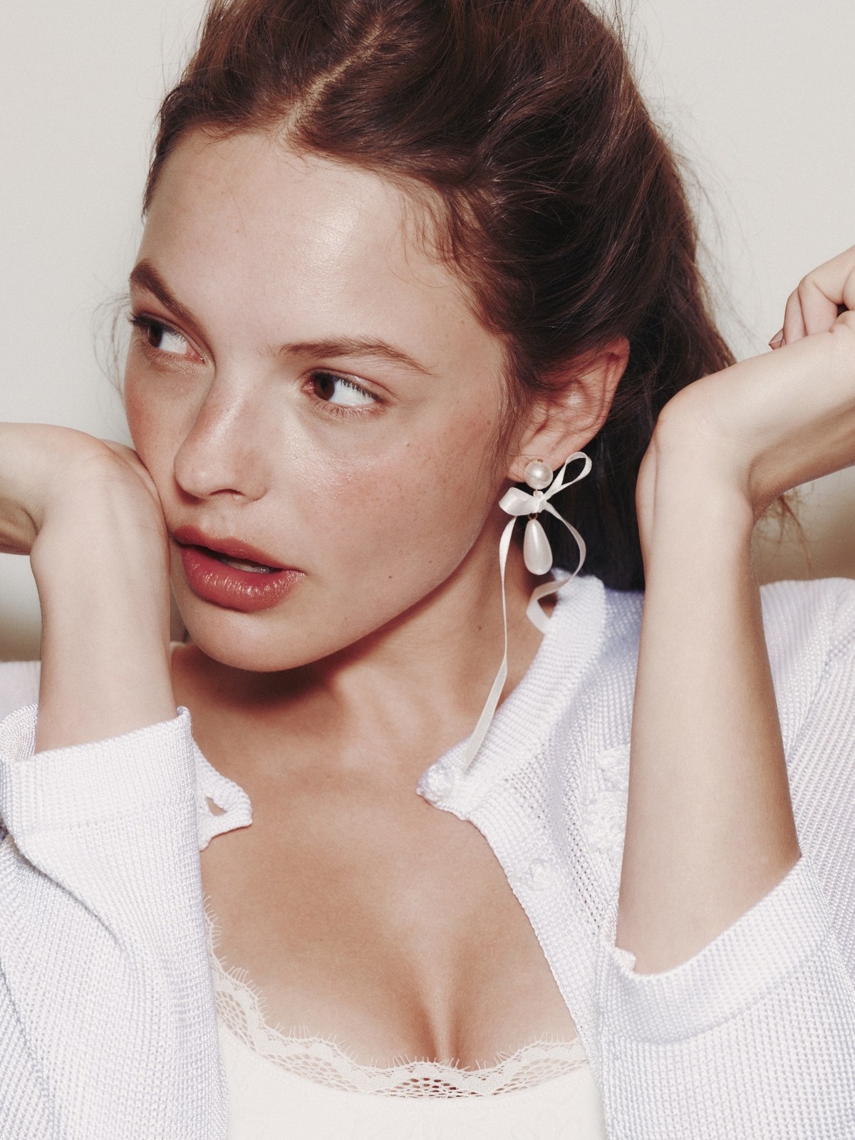 Red-haired model in a white blouse and sculptural earrings