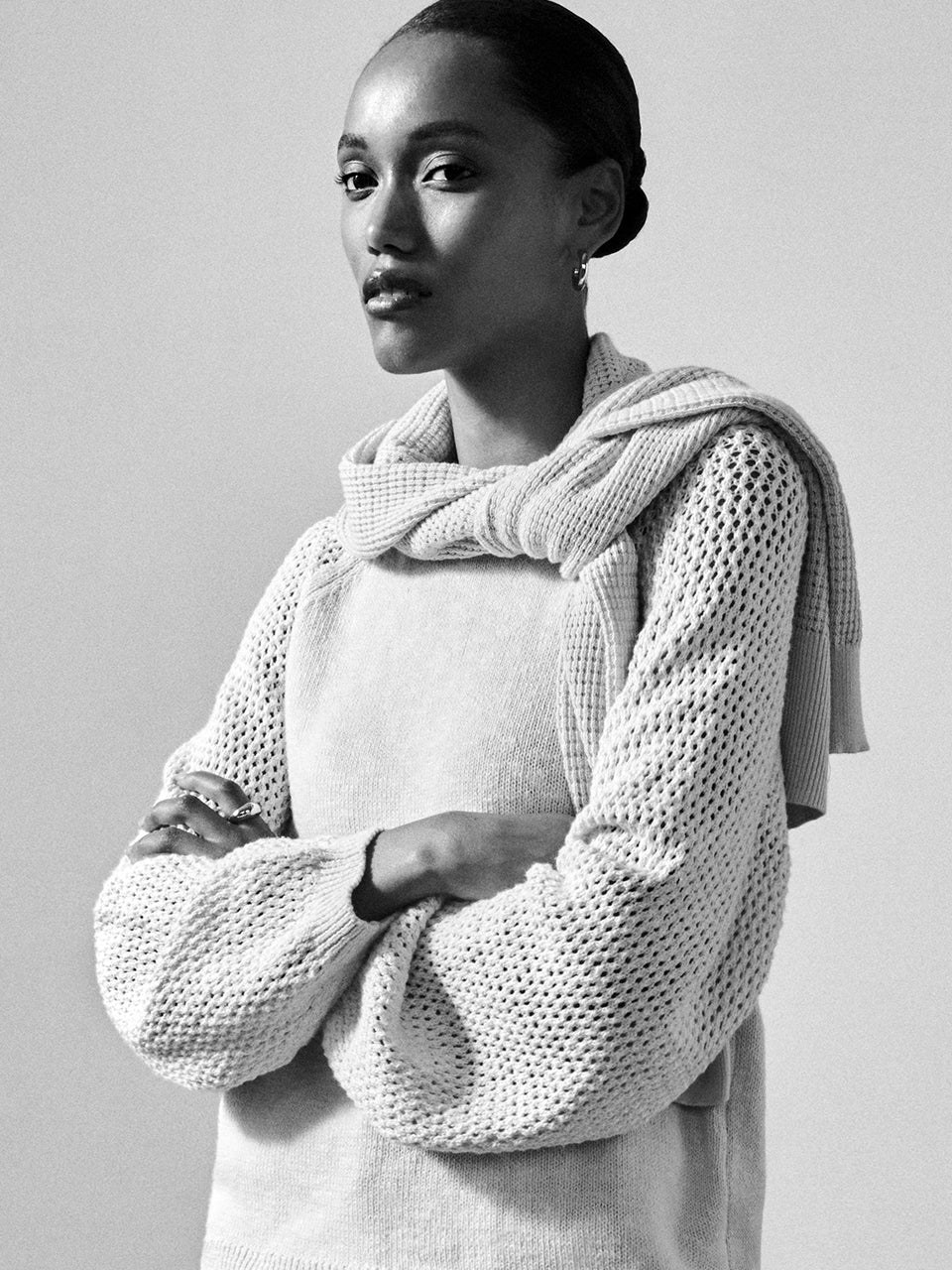Black-and-white portrait of a model in a textured sweater and scarf