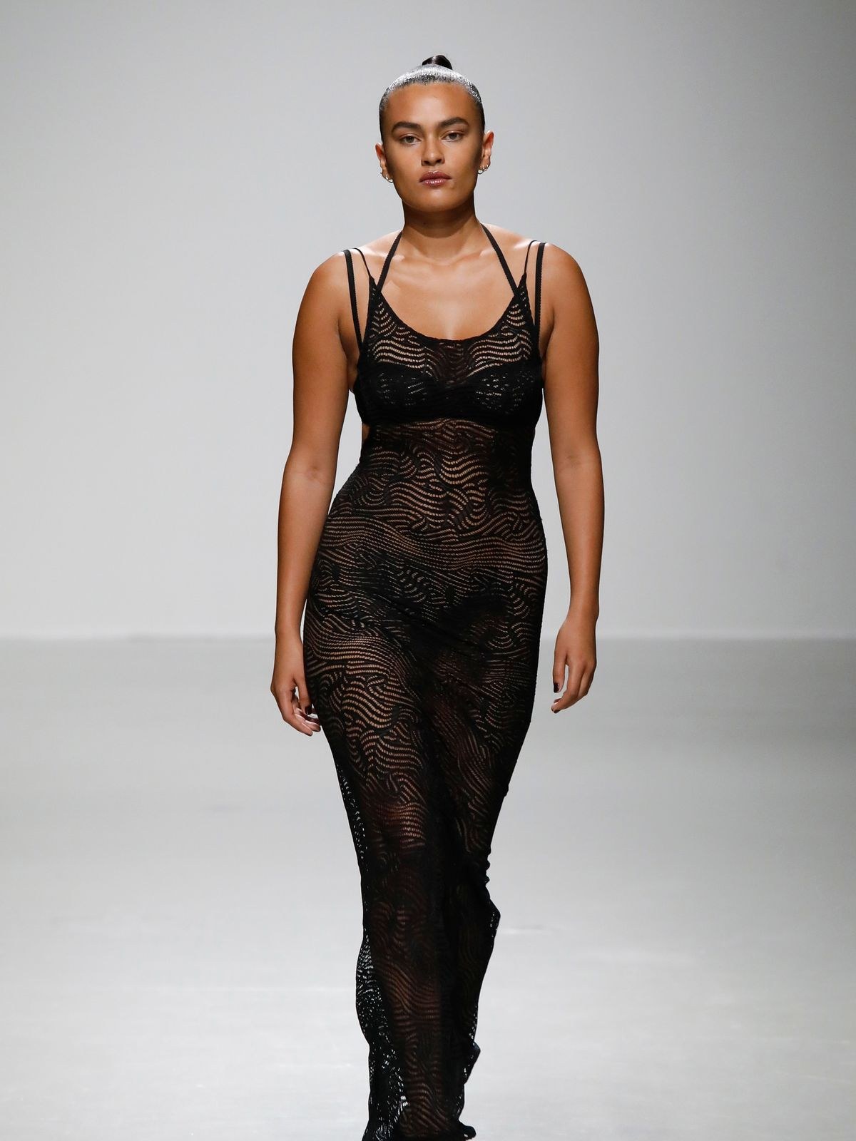 Model walking in a long black sheer Atlein dress