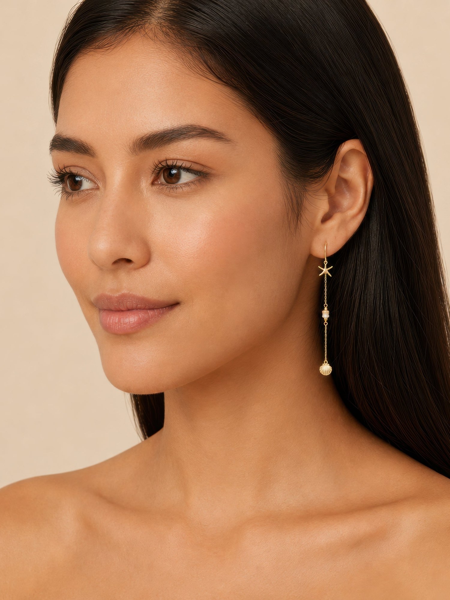 Model in long gold drop earrings