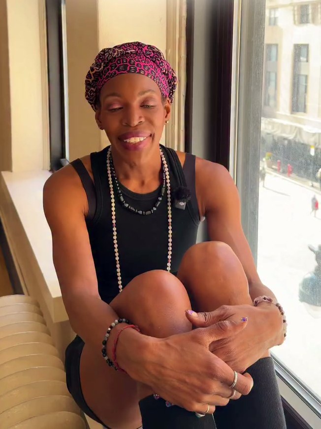 Choreographer Briana J. Reed seated by a window for a campaign conversation portrait
