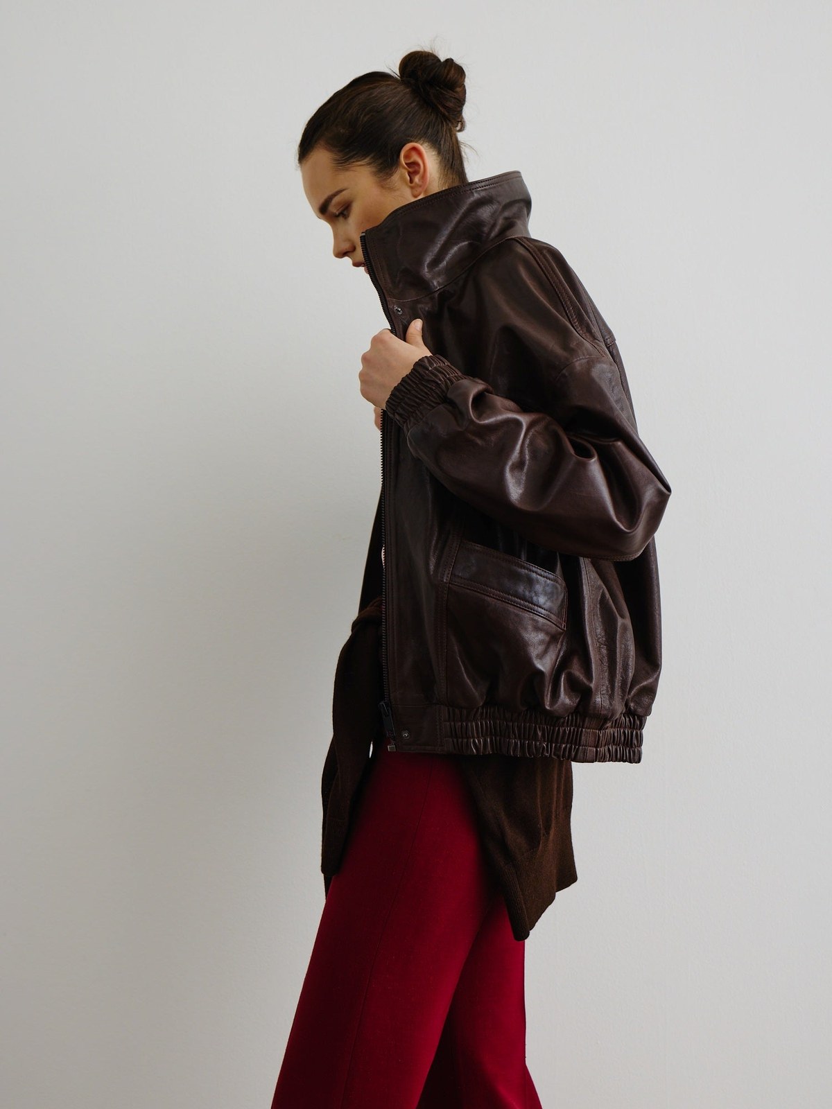 Model in a dark leather Smythe jacket and red trousers