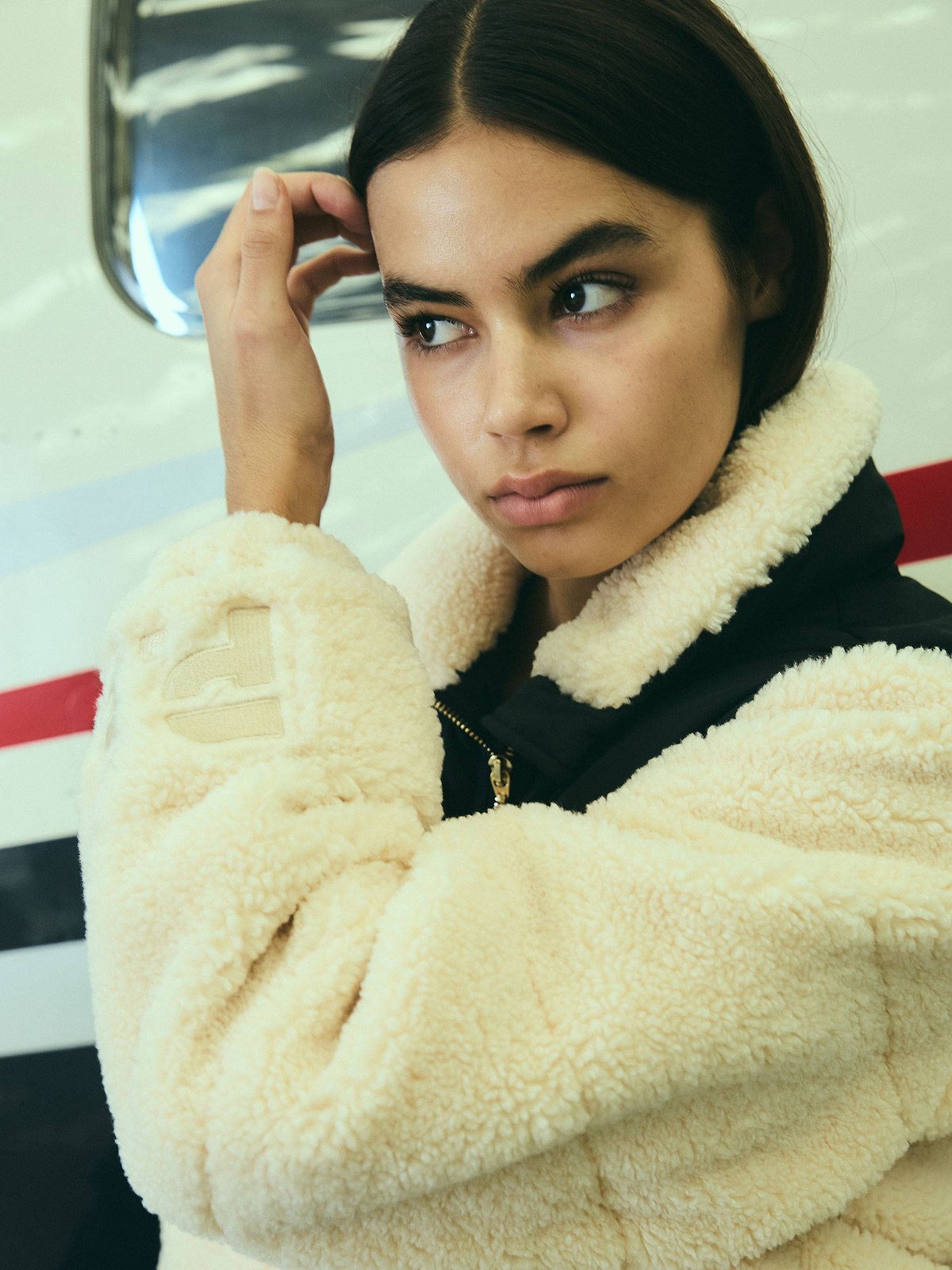 Model in a cream fleece jacket looking to the side
