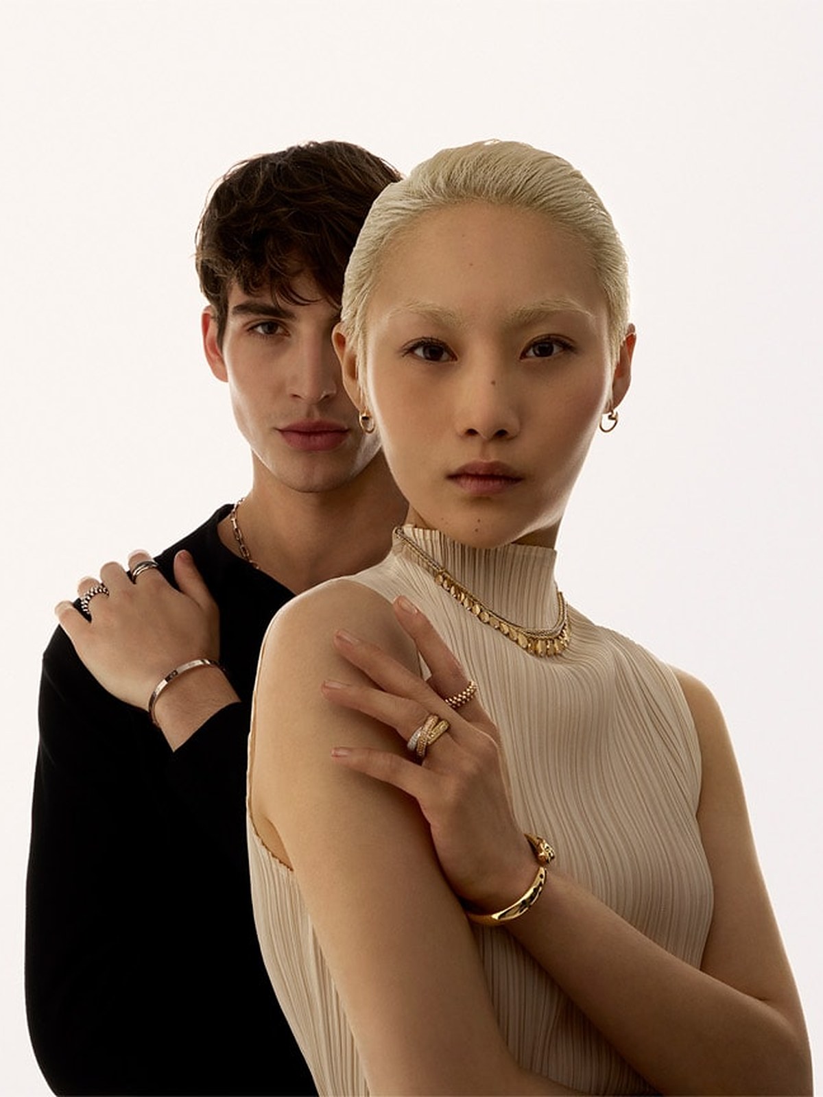 Couple wearing gold necklaces, rings and bracelets