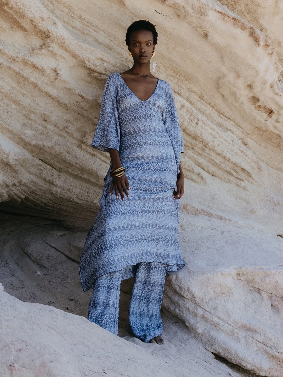Model in a blue Hanne Bloch knit set framed by pale rock formations