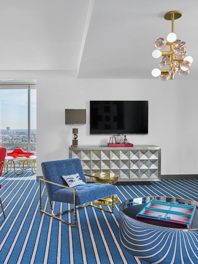 Bright living room with striped blue rug and red chairs