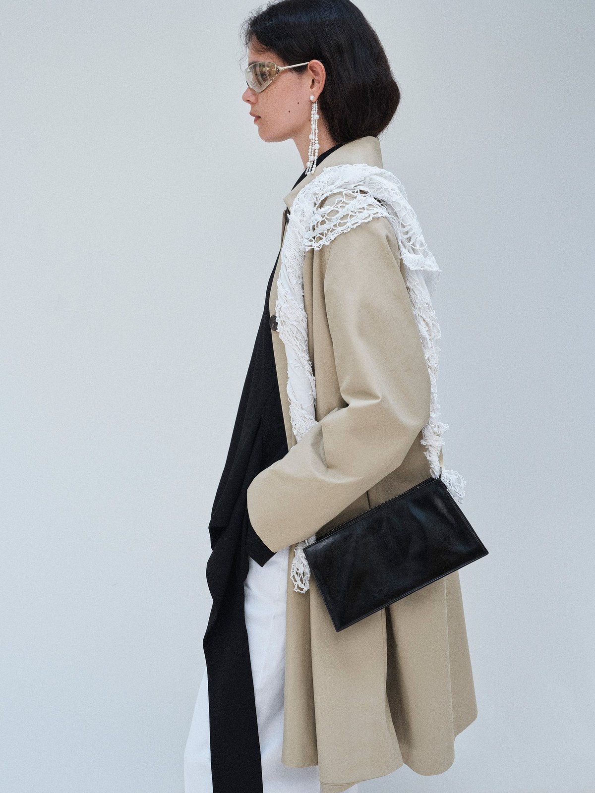 Model in a light coat and layered black outfit in the Beaufille FW26 lookbook