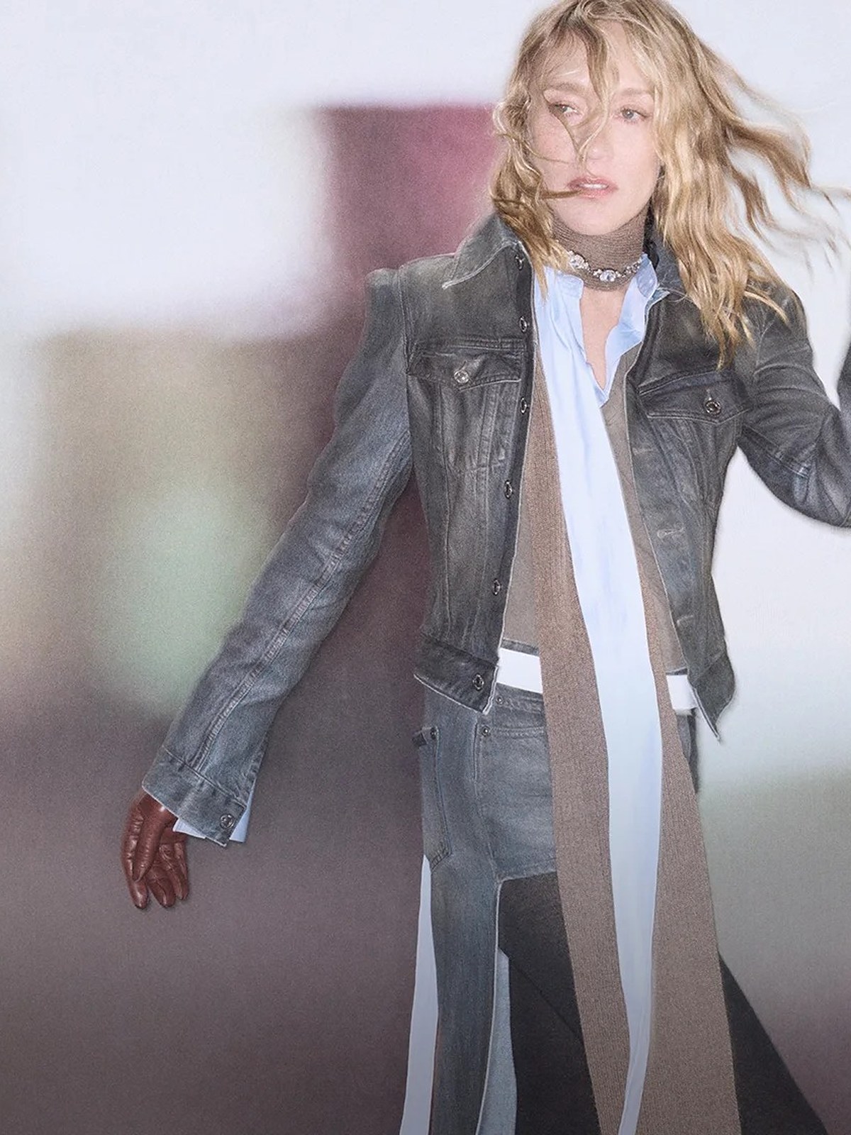 Blonde model in a distressed leather jacket, long scarf and denim