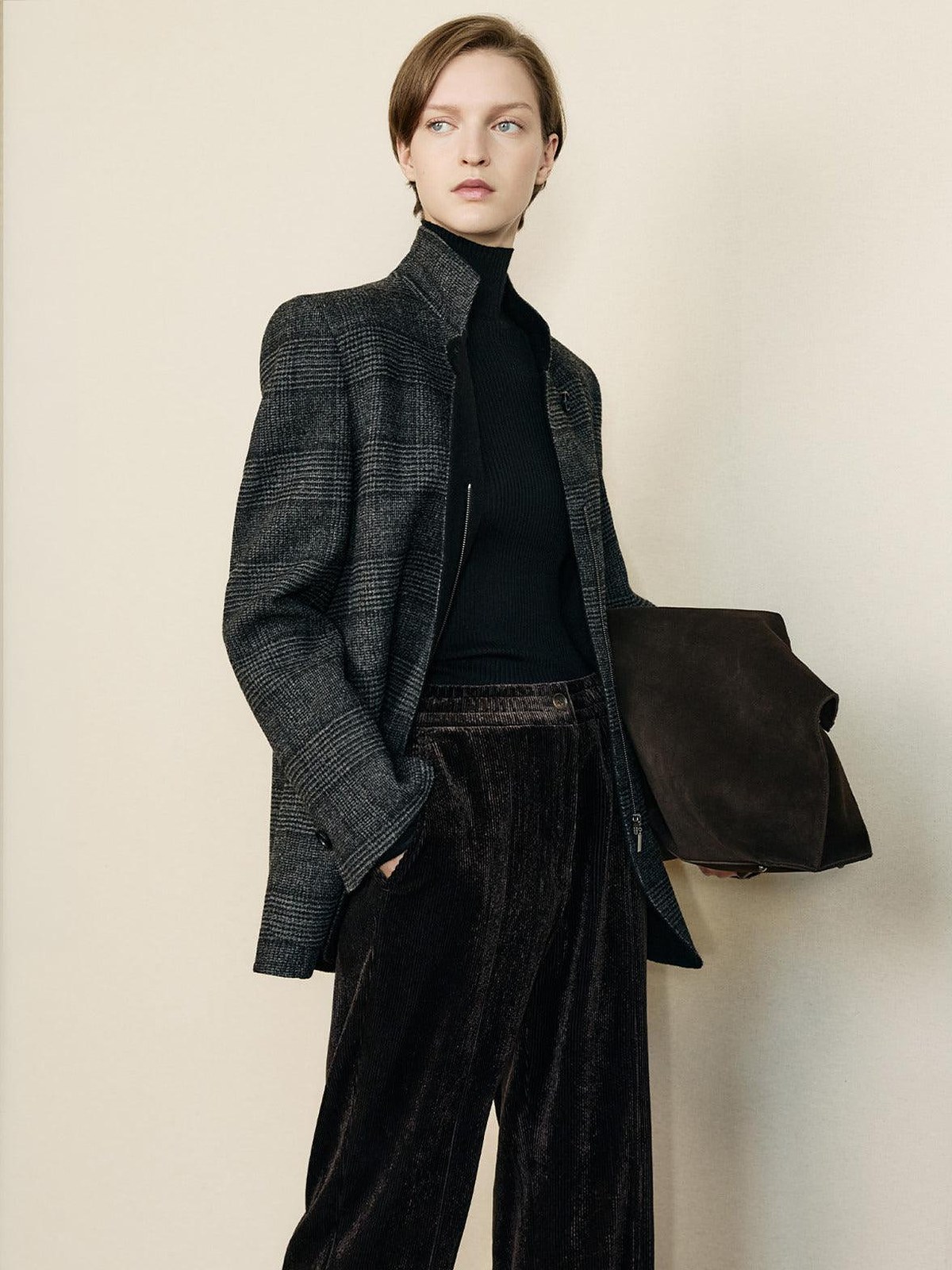 Model in a charcoal check blazer, black turtleneck and velvet trousers