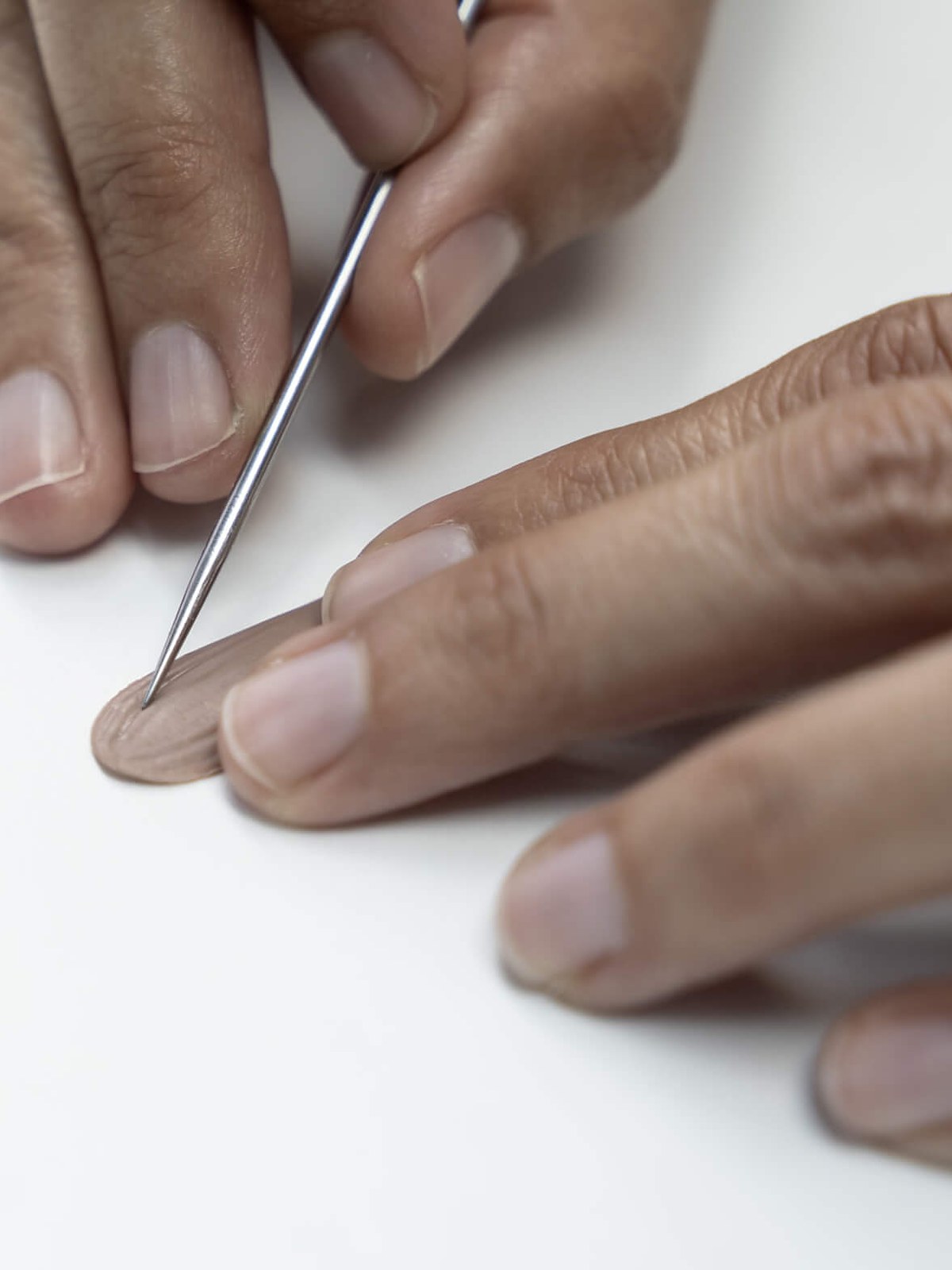 Hands shaping small porcelain petals with a tool