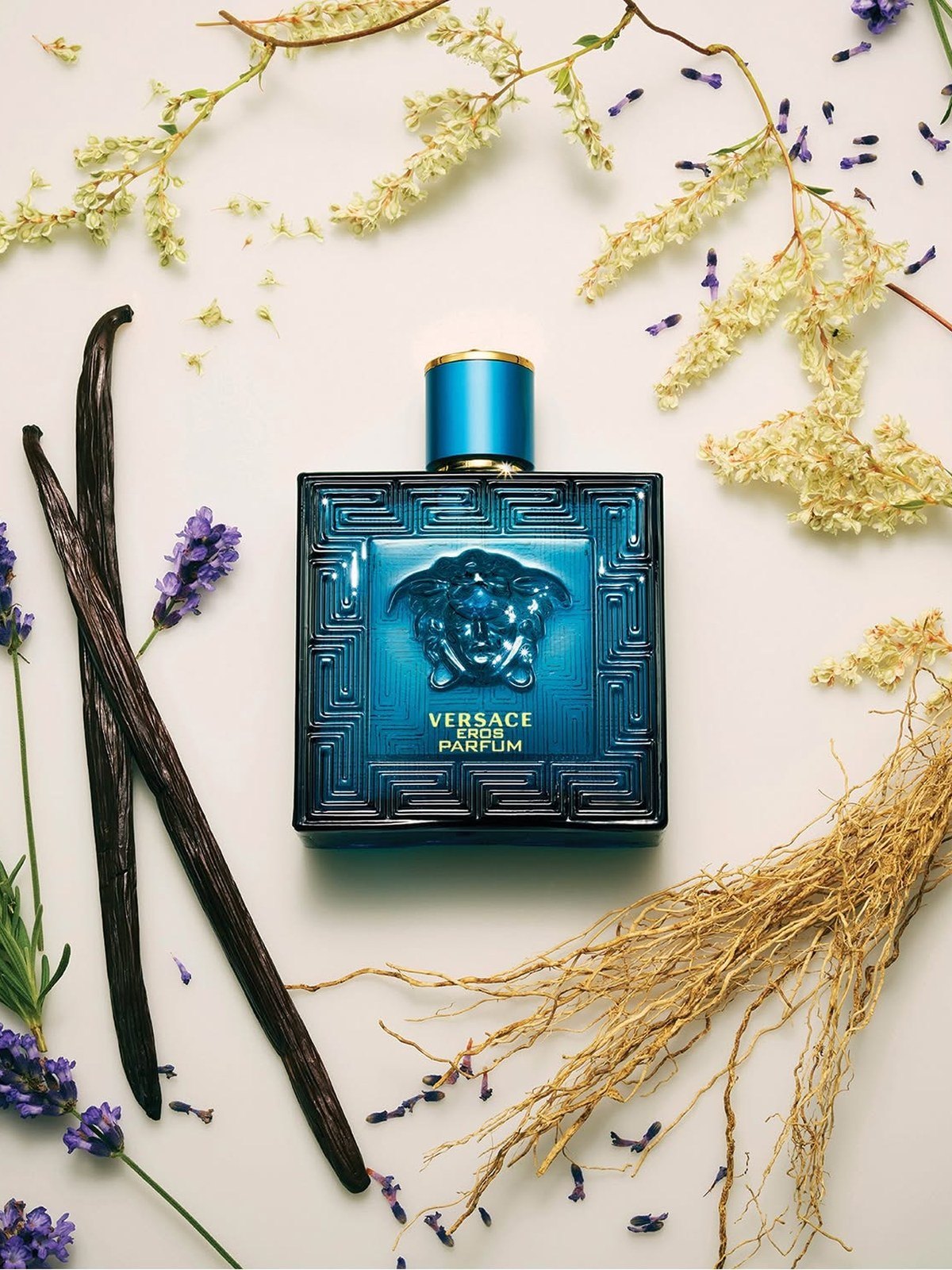 Blue Versace Eros Parfum bottle surrounded by vanilla beans and dried lavender