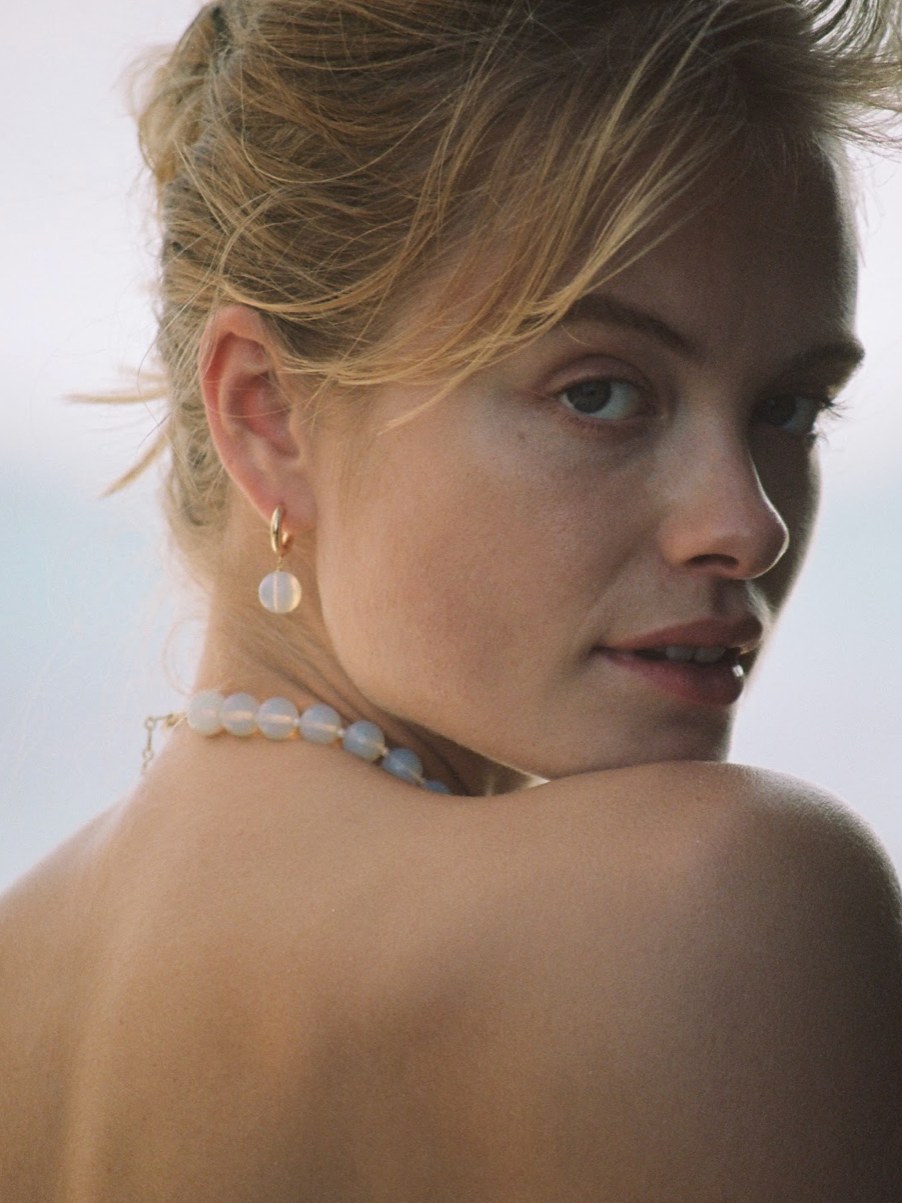 Model wearing pearl ANNI LU earrings and a white beaded necklace