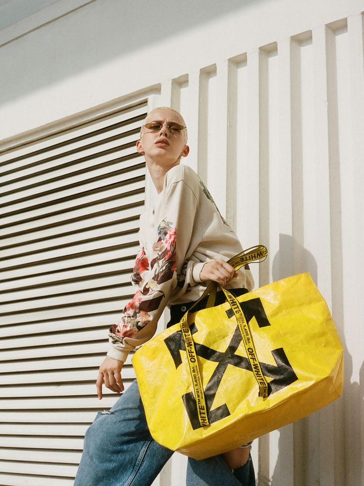 Woman in a white outfit carrying a yellow Off-White tote bag on the street