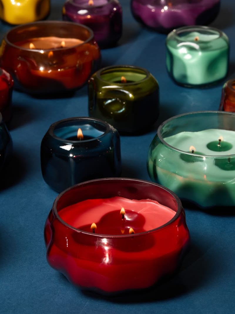 Colorful lit candles arranged on a deep blue surface