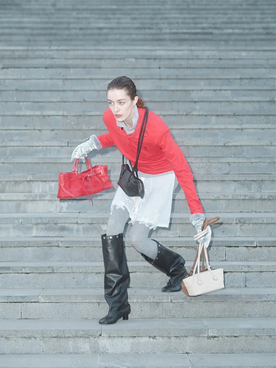 Model carrying colorful MARGESHERWOOD bags on a concrete staircase