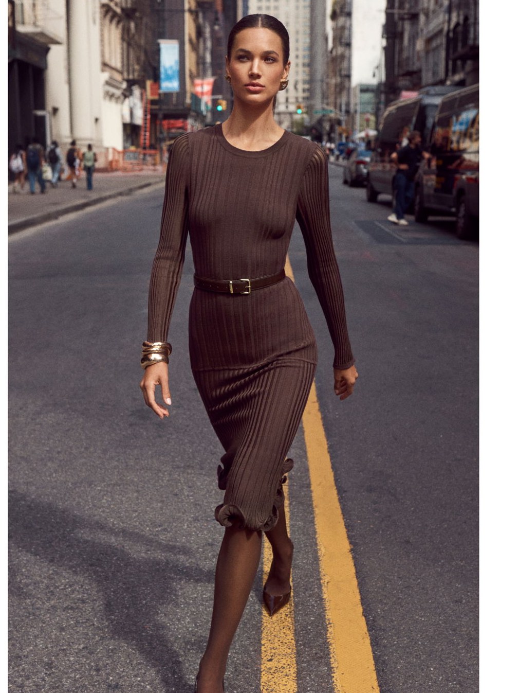 Model in a ribbed brown dress walking a New York street