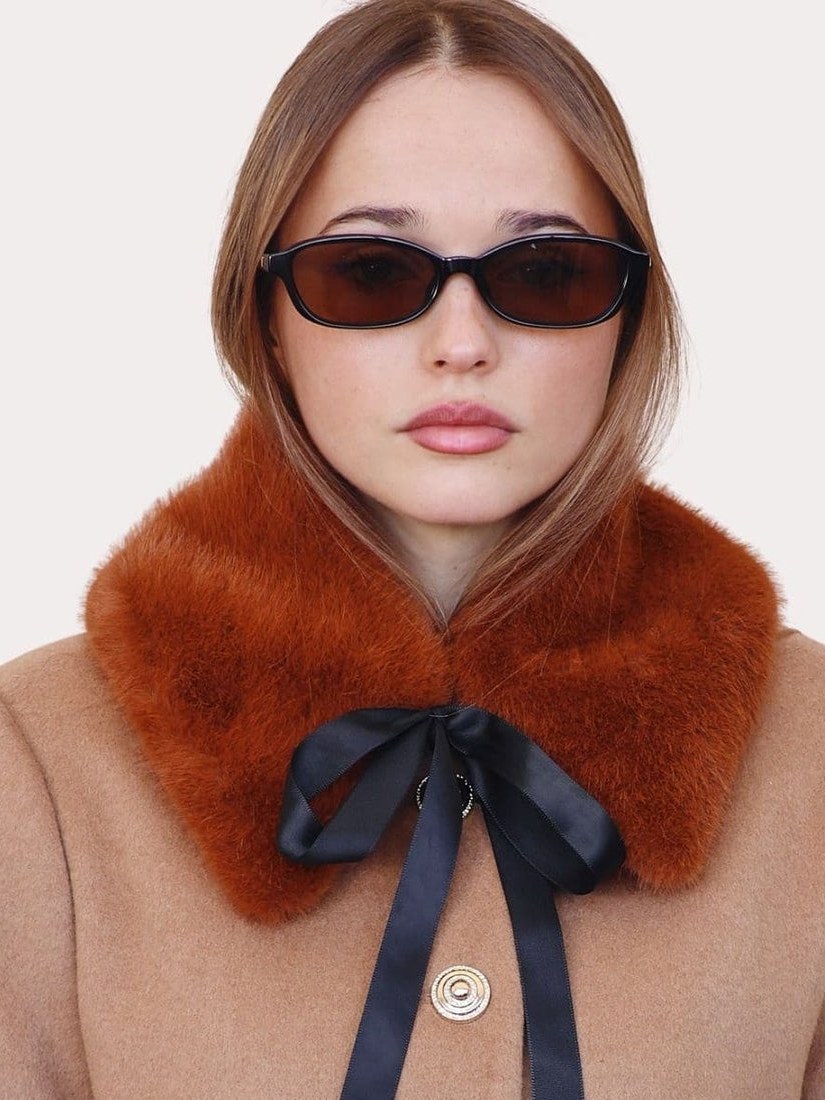 Model in a camel coat and plush collar with dark sunglasses