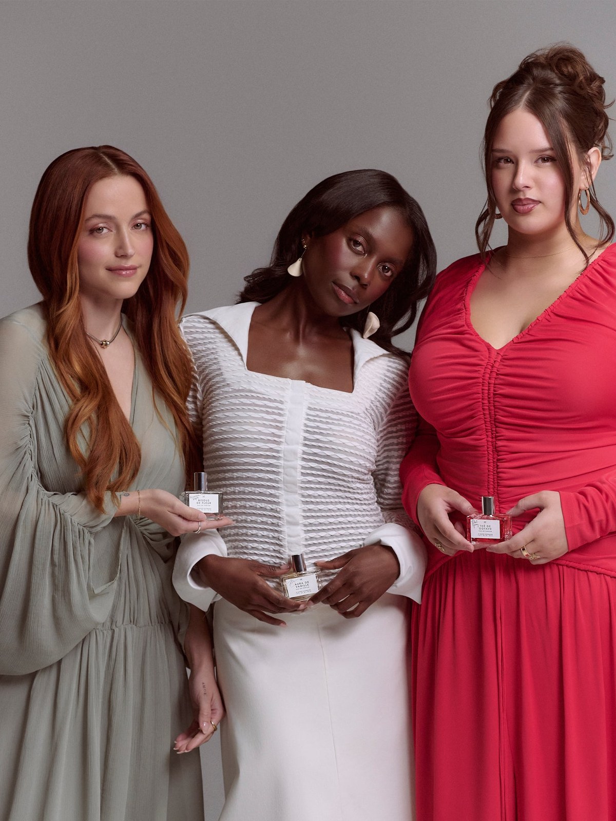 Three Coterie creators holding Le Monde Gourmand fragrances in a studio portrait