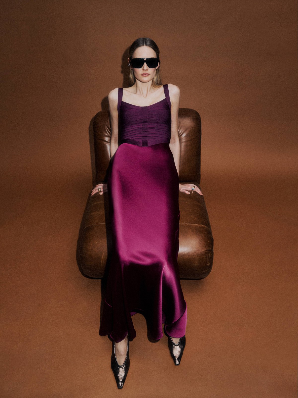 Woman in a purple gown seated in a brown leather chair