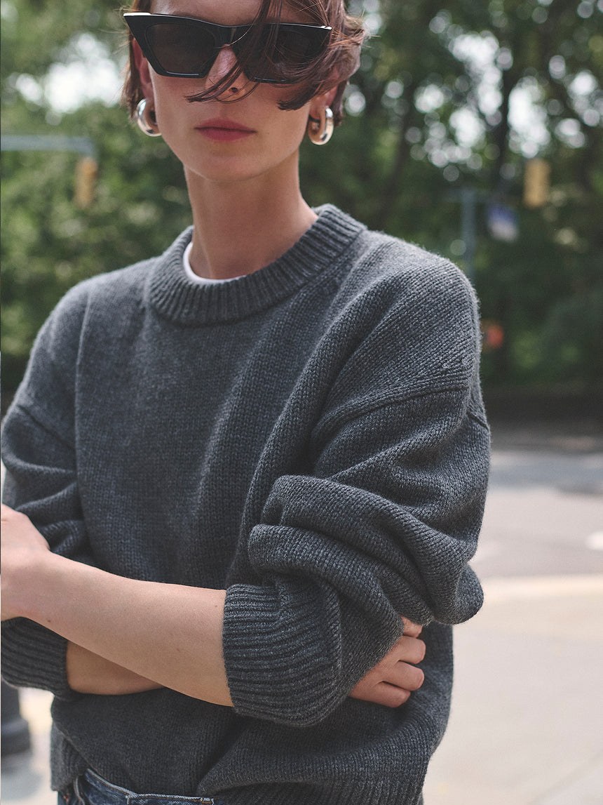 Model in a charcoal knit sweater outdoors