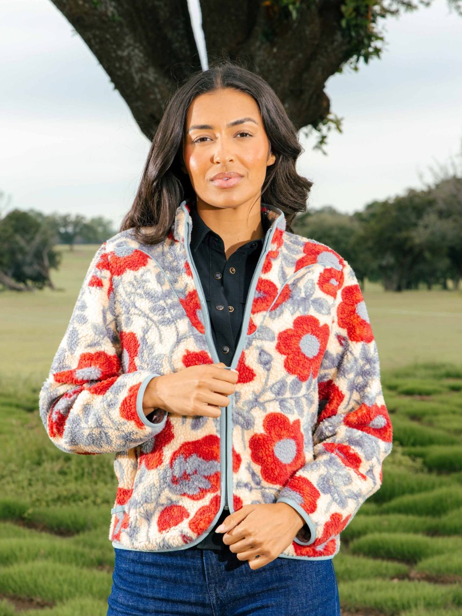 Woman in a floral fleece jacket standing in a green field
