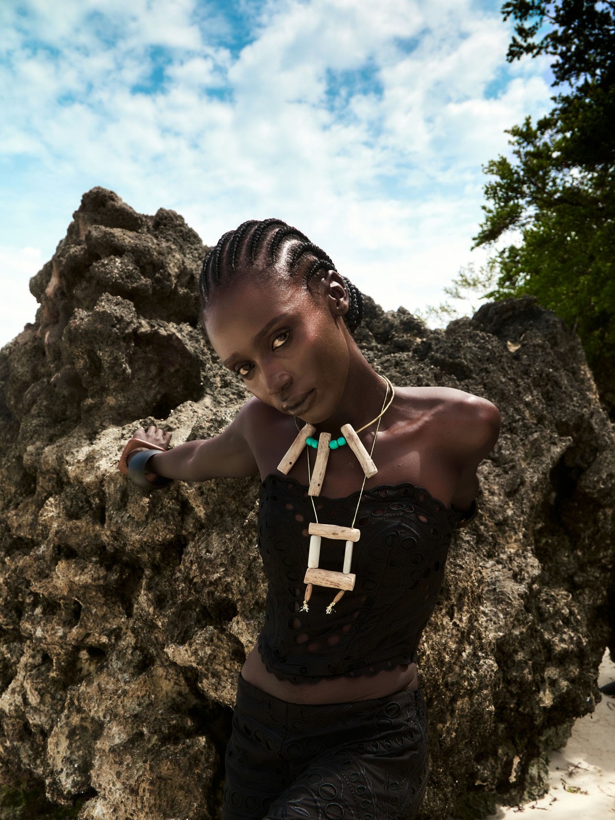Model in a black lace look against Zanzibar rocks