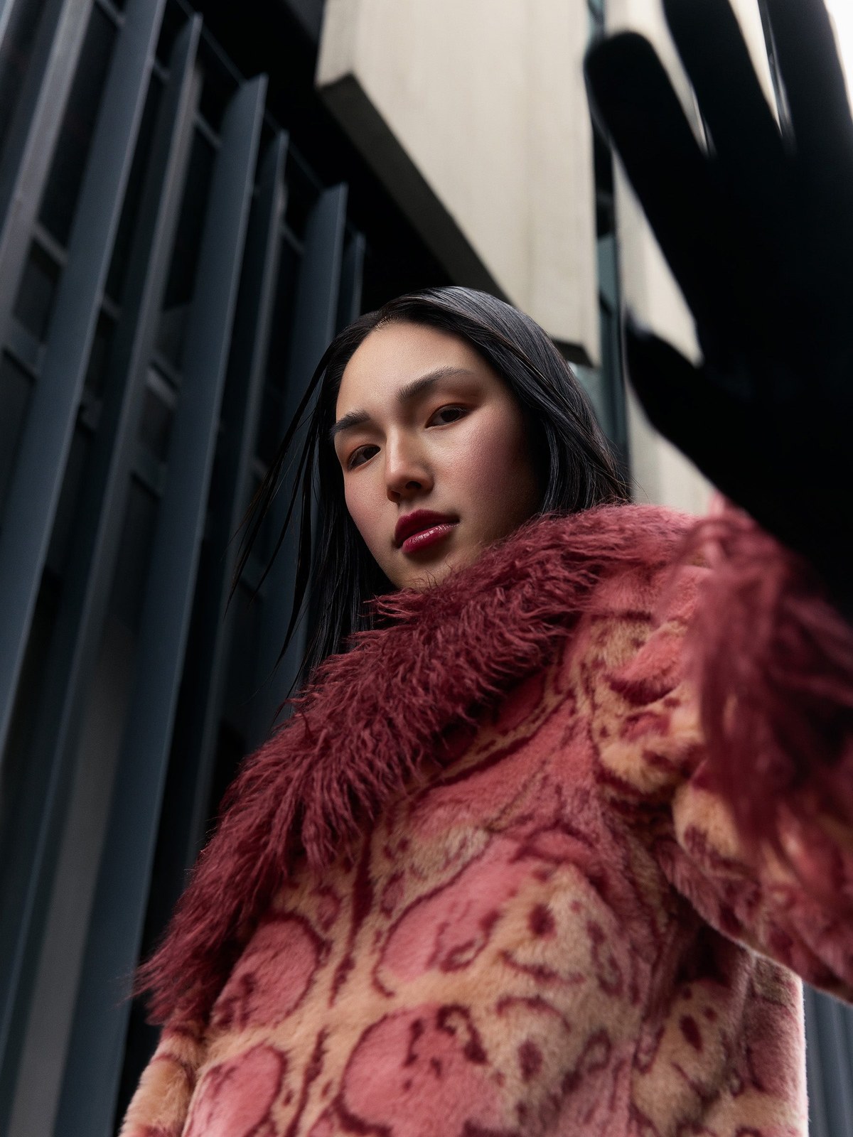 Model in a rose patterned faux fur coat in an urban setting