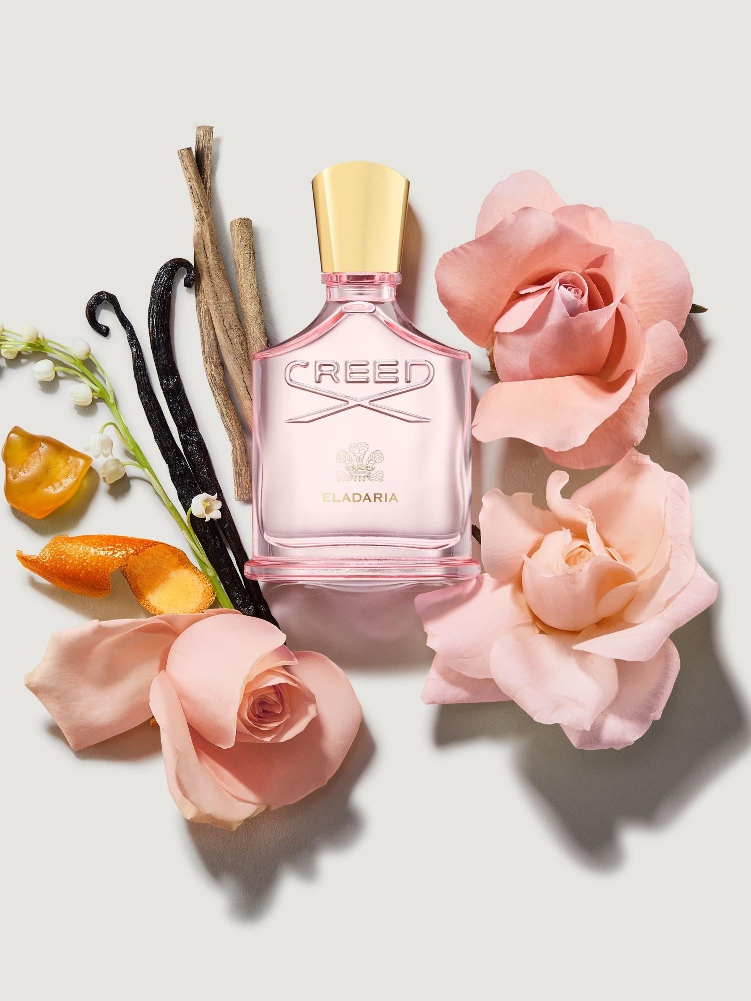 Eladaria bottle styled with peach roses, vanilla pods and lily of the valley
