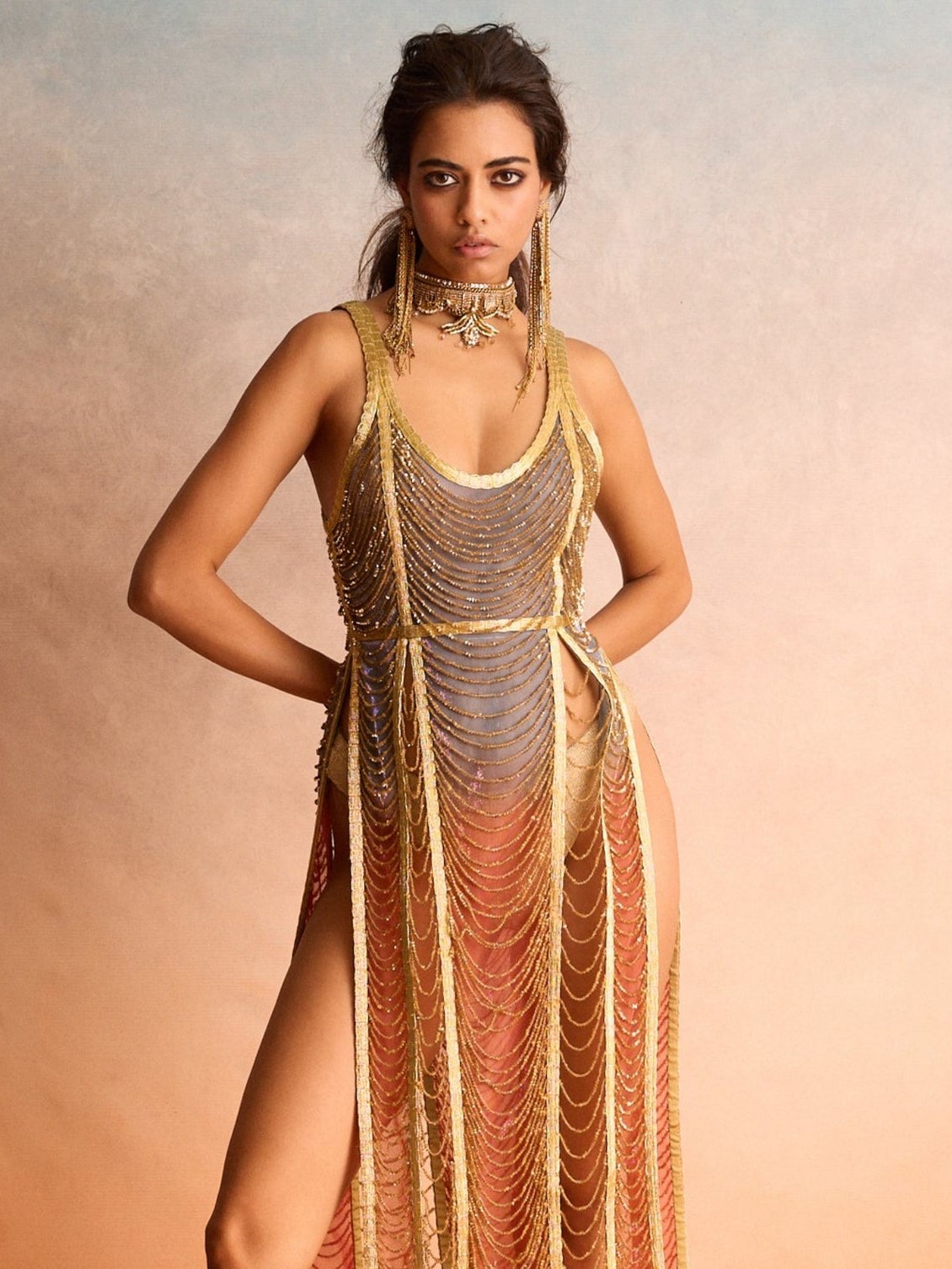 Model in a black embellished jacket with a sculptural gold necklace