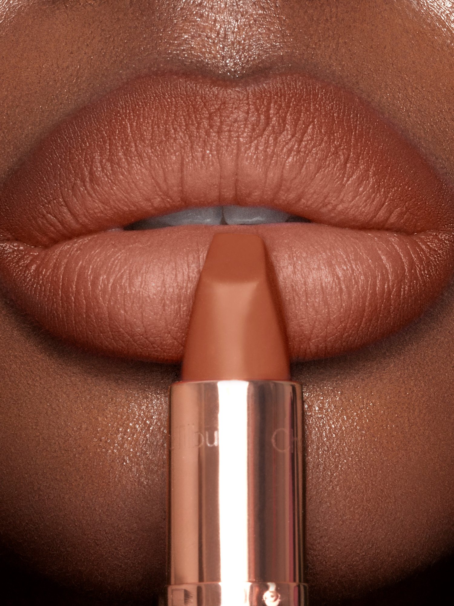 Close-up of lips in a warm caramel nude matte lipstick