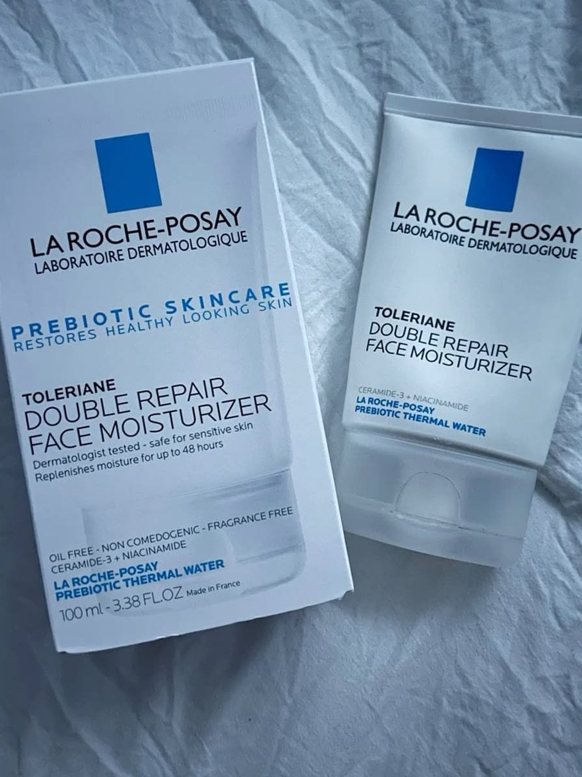 La Roche-Posay Toleriane Double Repair Face Moisturizer tube and its box on crumpled white bedding