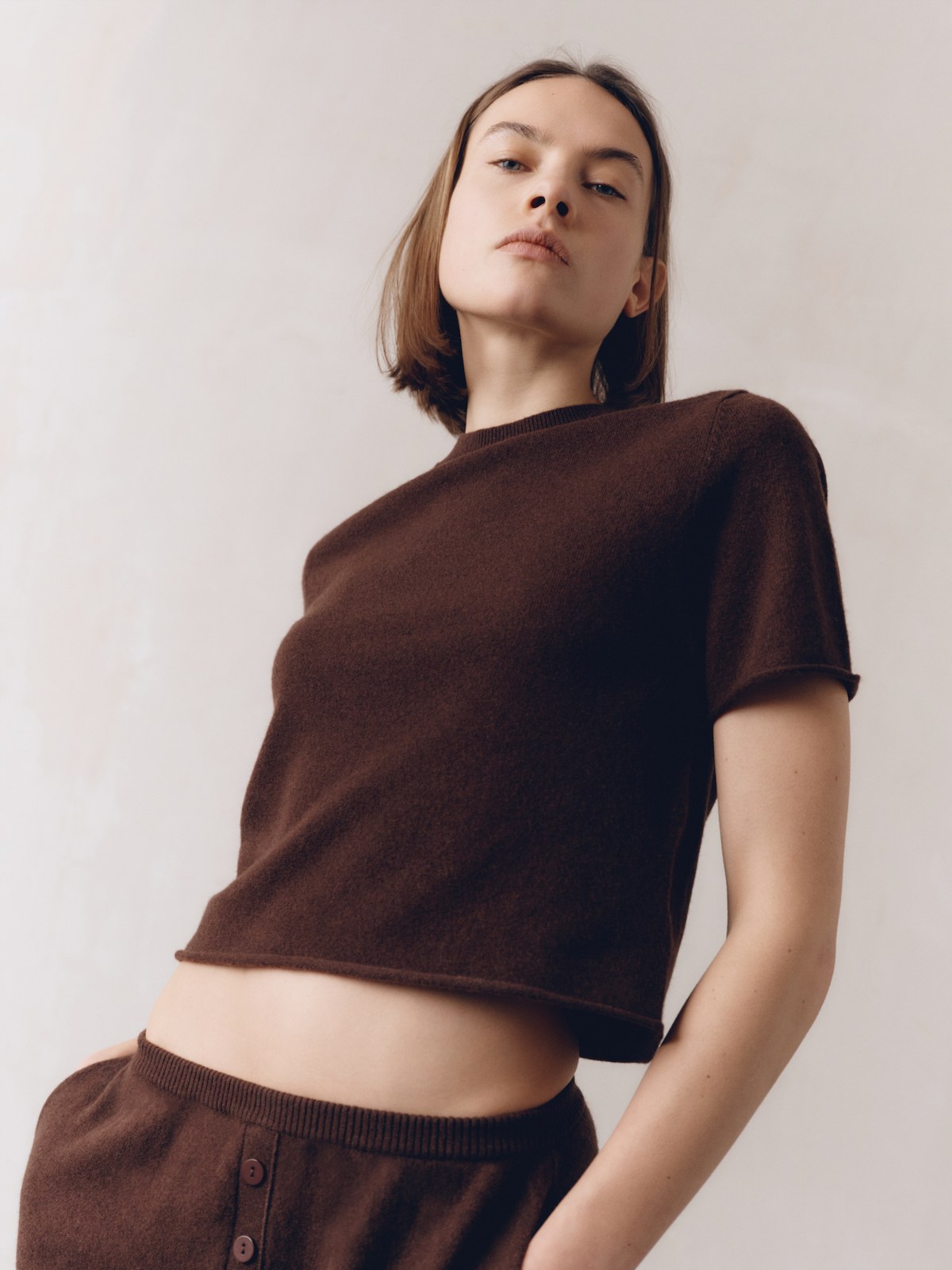 Model wearing a brown short-sleeved cashmere top and matching pants