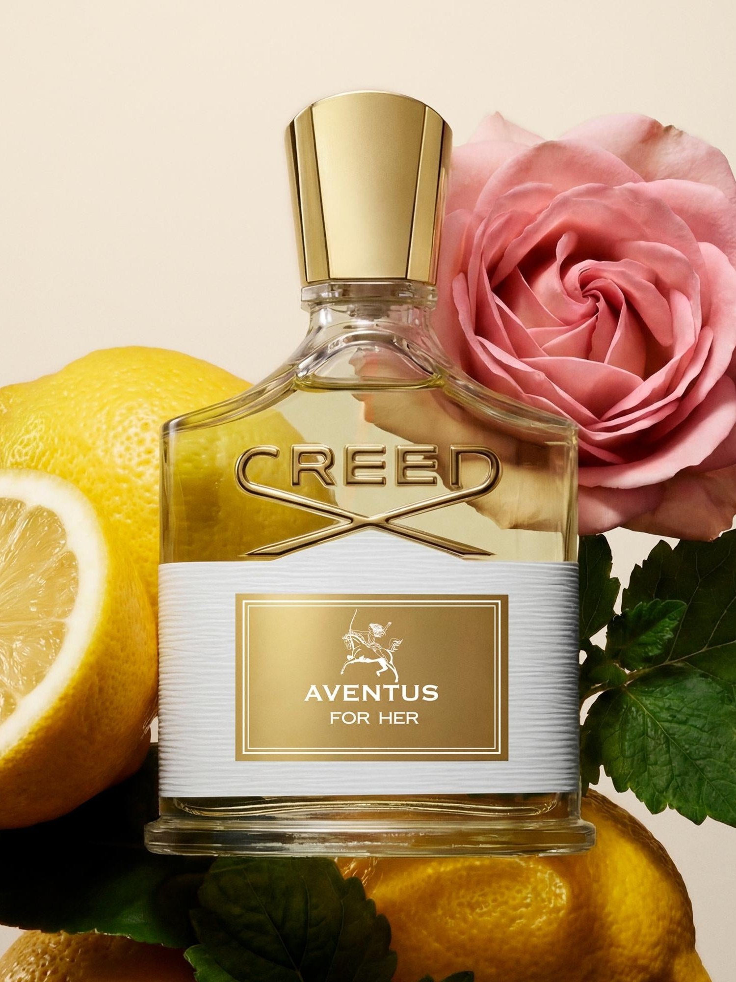 Aventus for Her bottle with cut lemons and a pink rose