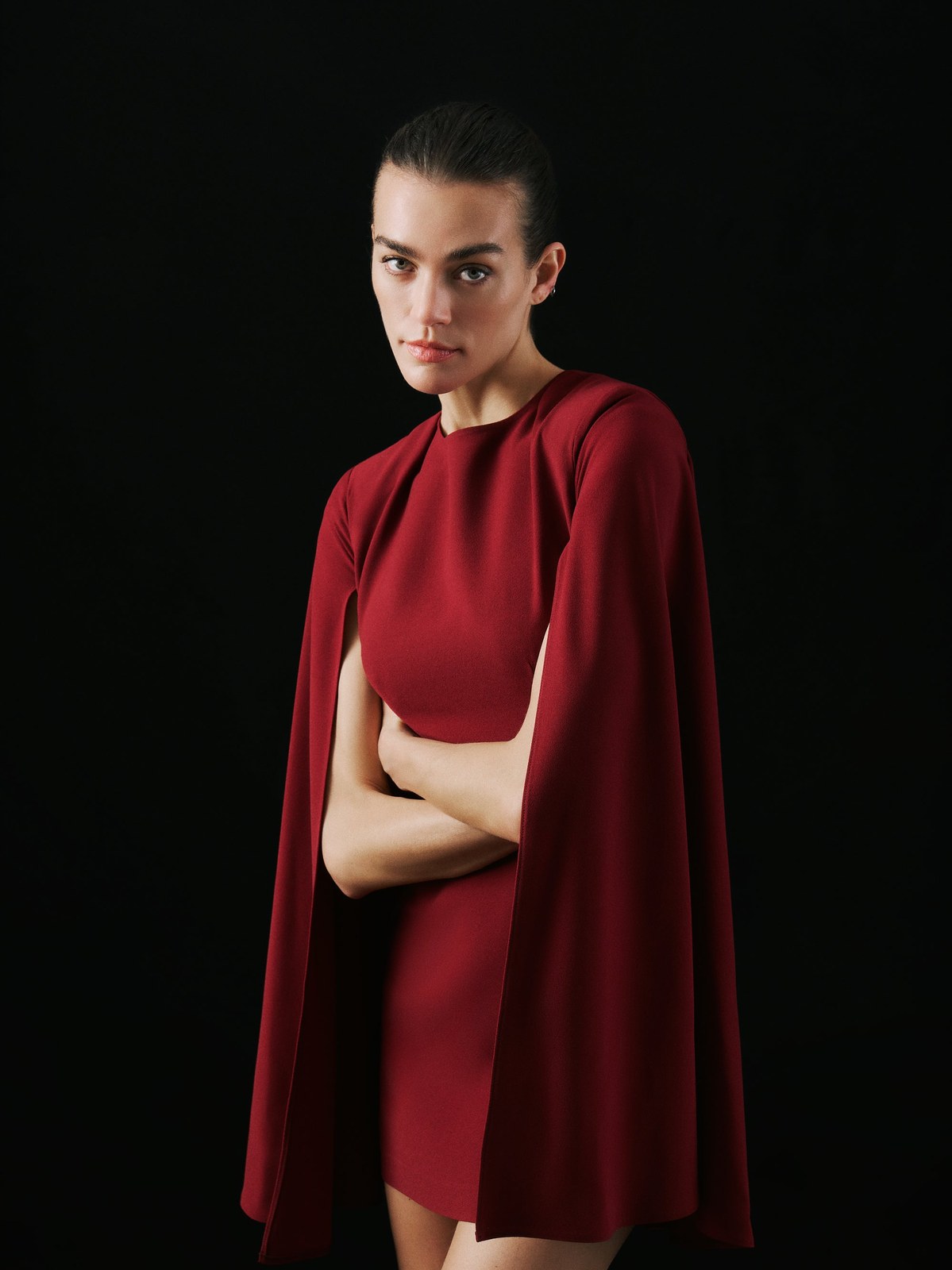 Model in a burgundy cape dress from the Fall Winter lookbook