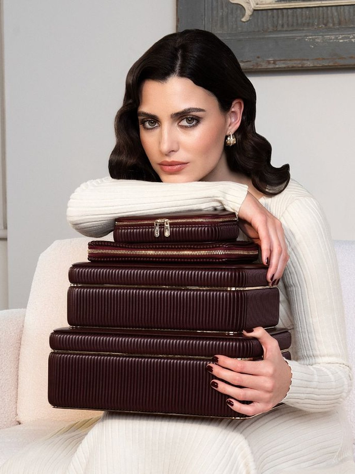Woman holding a stack of burgundy WOLF jewelry cases