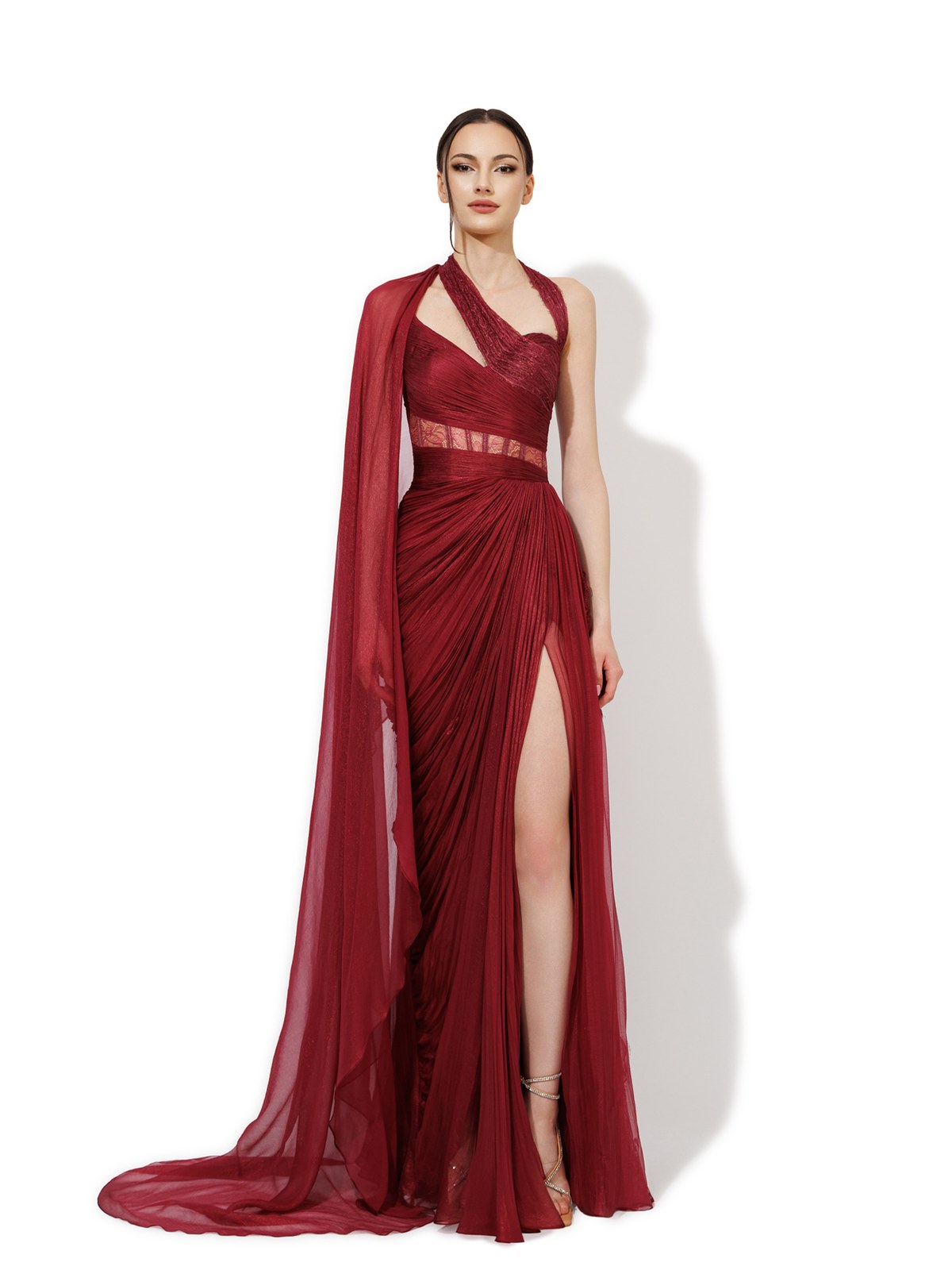 Model in a red gown with a sheer cape and high slit