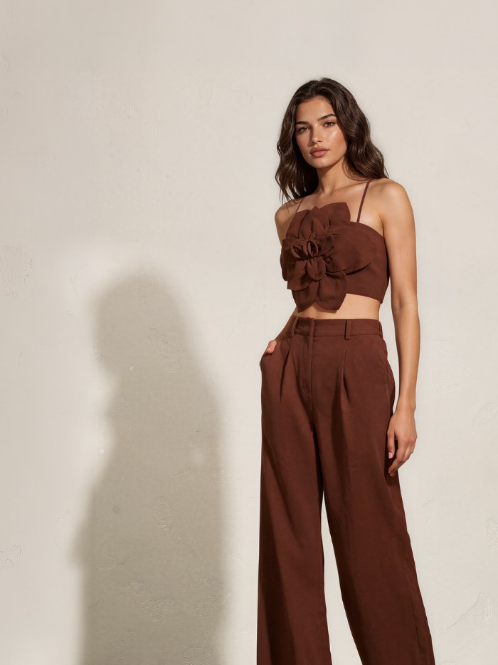 Model in a brown flower-detail top and matching trousers in a neutral studio