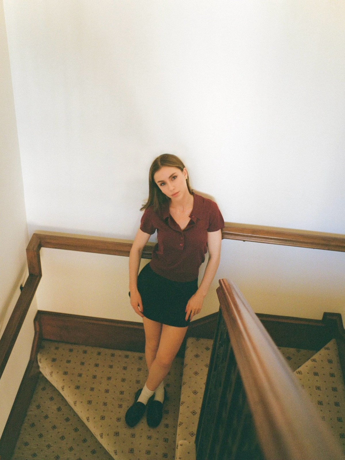 Woman in a dark top and shorts seated on a staircase
