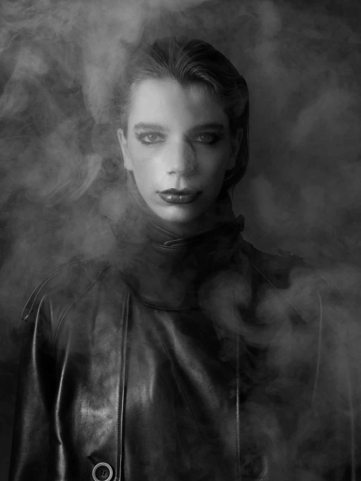 Vera Kuntz in a leather look surrounded by smoke in a monochrome portrait