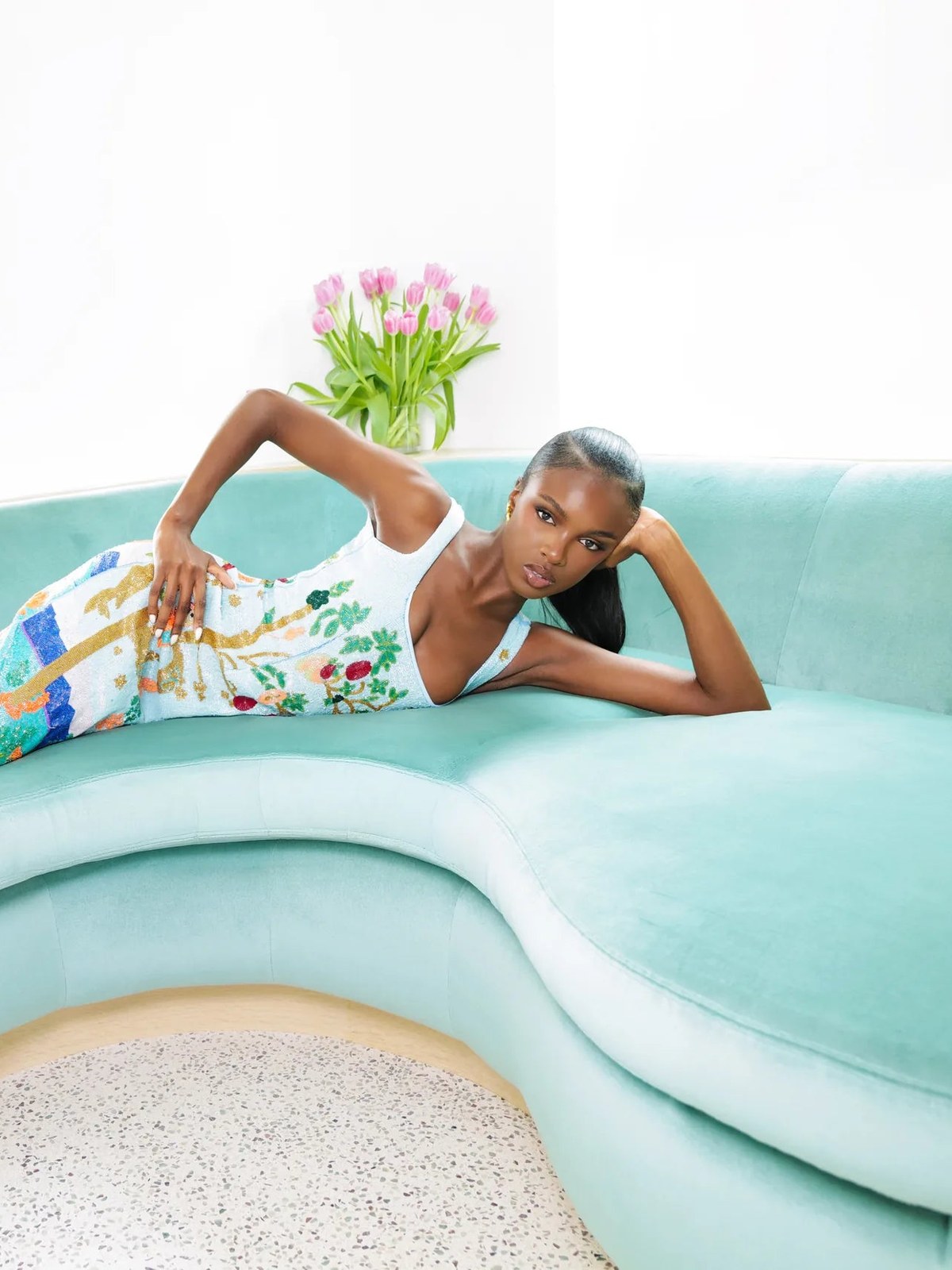 Model reclining on a mint poolside daybed in a colorful Oceanus swimsuit