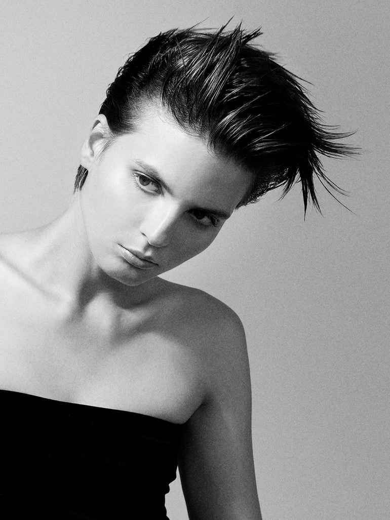 Model with sculpted, swept-up hair in a monochrome studio portrait