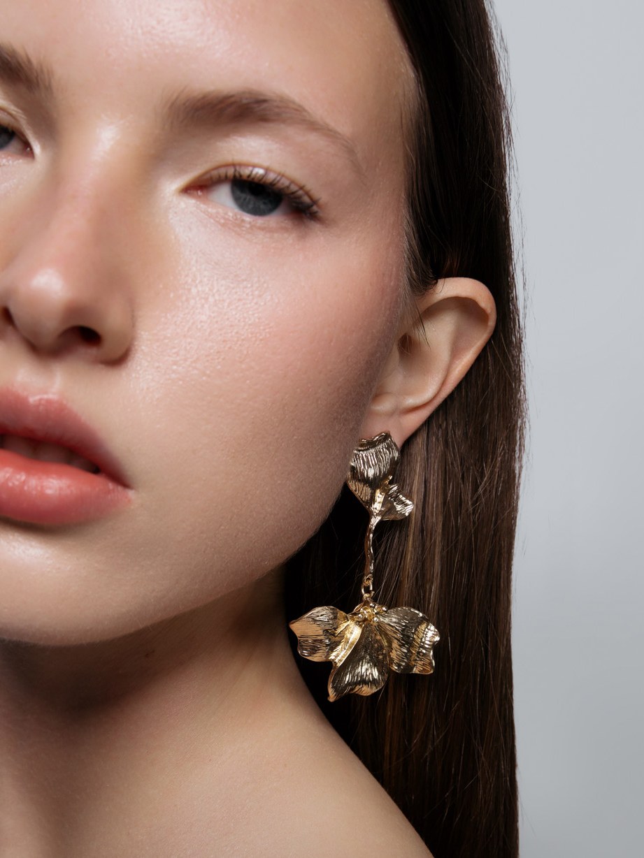 Close studio portrait of a model wearing sculptural SHASHI drop earrings