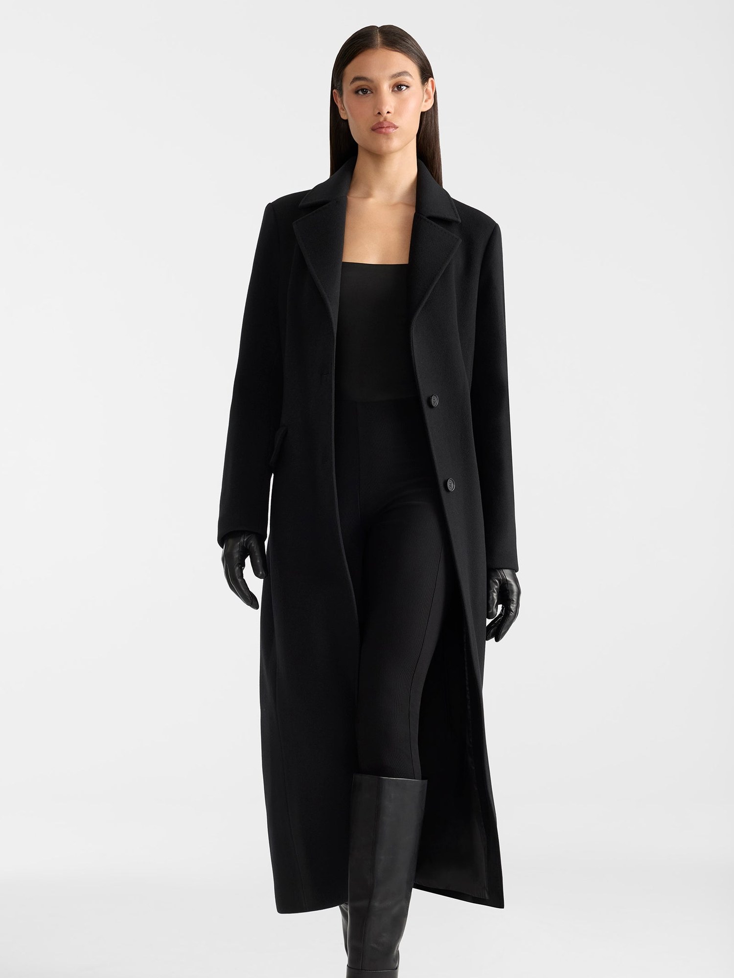 Model in a long black wool coat and black leather gloves
