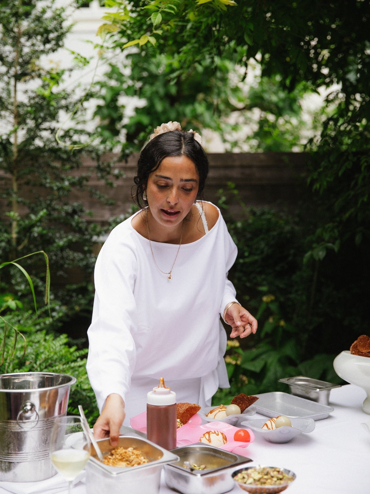 Woman preparing a meal outdoors beside Abel fragrance bottles