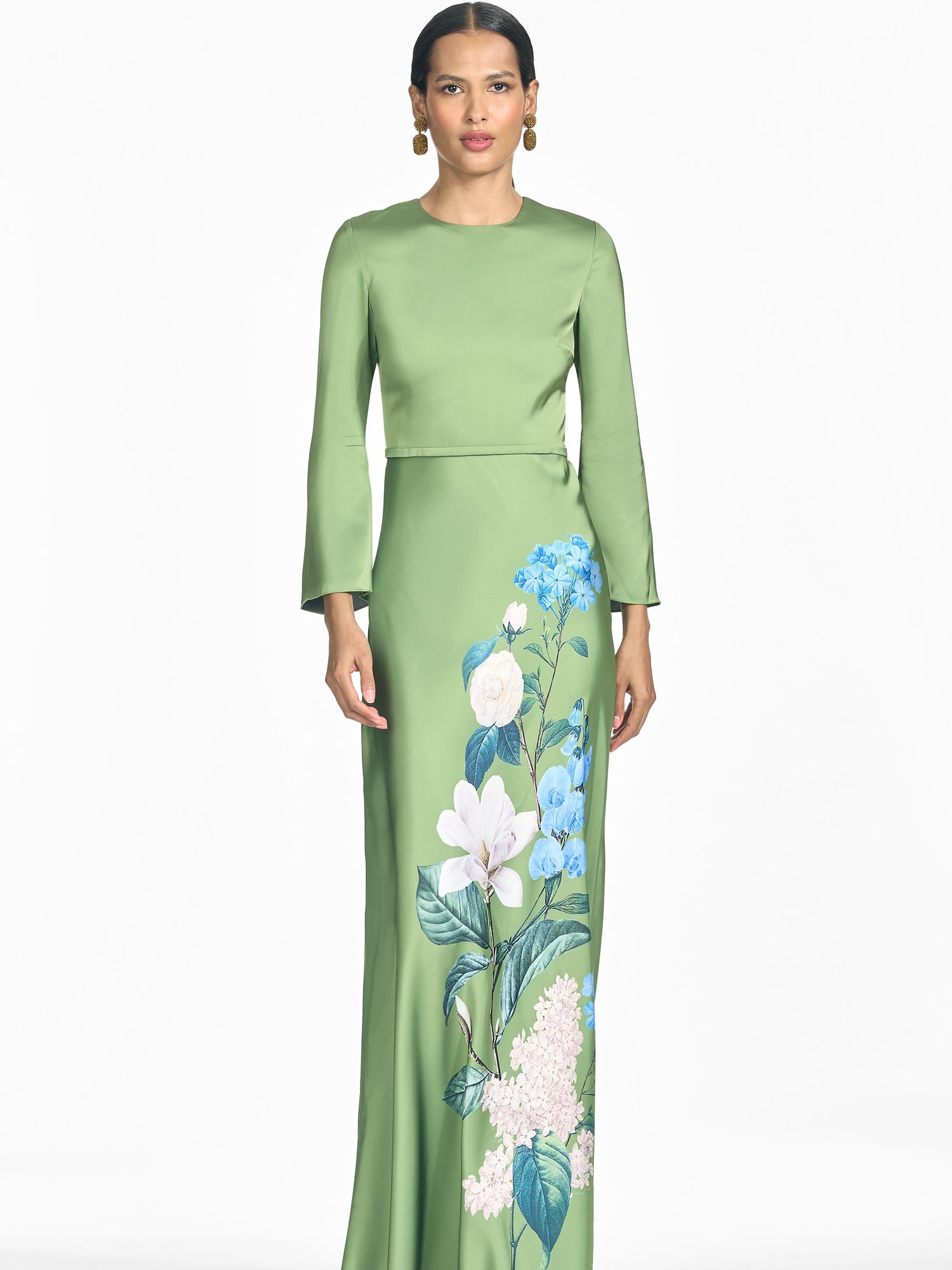 Model in a green satin long sleeve gown with a hand painted blue and white floral