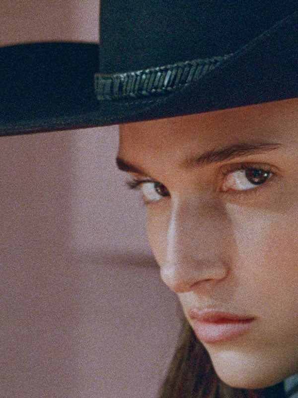 Close portrait of a model wearing a dark wide-brim cowboy hat
