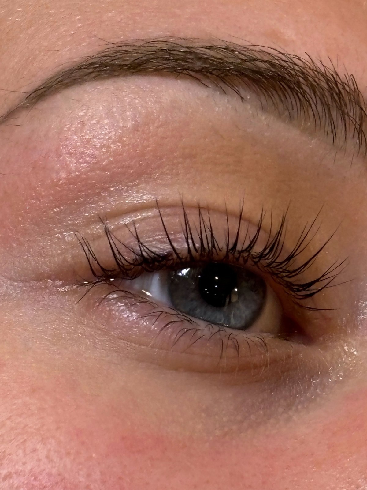 Close up of an eye with long dark lashes and a gold hoop earring