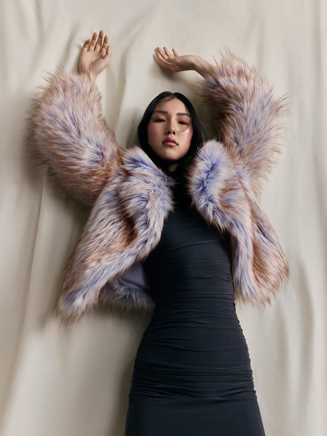 Model in a pastel multicolored faux fur jacket against a light studio backdrop